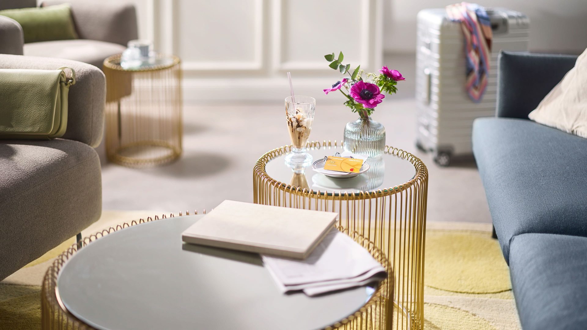Gold Credit Card liegt auf einem kleinen Tisch, daneben ein Becher mit Eis 