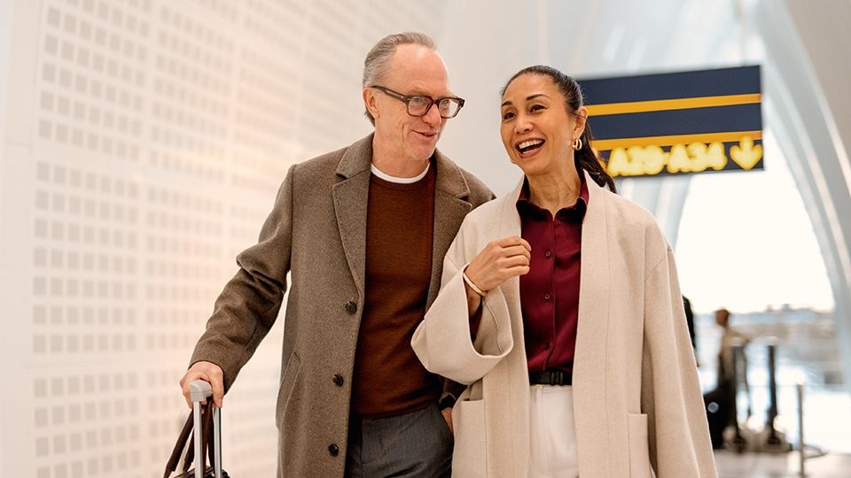 Zwei Reisende mit Gepäck unterwegs in einem modernen Terminal 